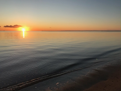 Aftensol over et roligt badevand.